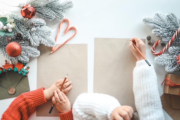 Children write a letter to Santa on craft sheets top view space for your text