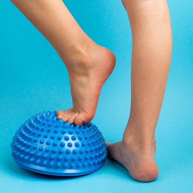 Children39s feet with a blue balancer on a light blue background treatment and prevention of flat feet valgus deformity of the foot