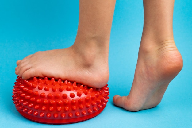 Children39s feet with a red balancer on a light blue background treatment and prevention of flat feet valgus deformity of the foot