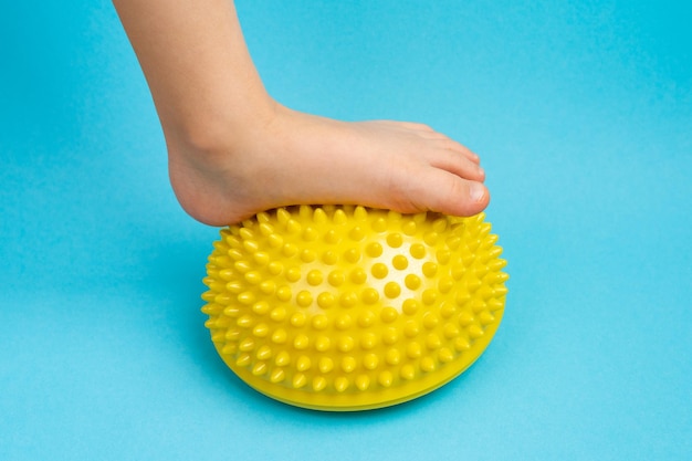 Children39s feet with a yellow balancer on a light blue background treatment and prevention of flat feet valgus deformity of the foot