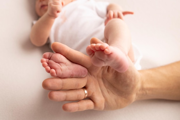 Children39s foot in the hands of mother father parents Feet of a tiny newborn close up Little baby legs Mom and her child Happy family concept Beautiful concept image of motherhood stock photo