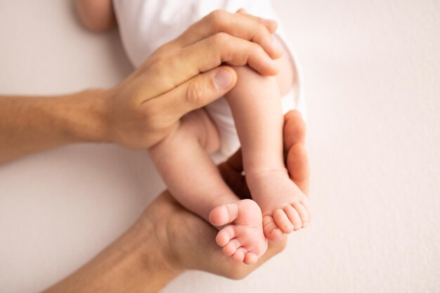 Children39s foot in the hands of mother father parents Feet of a tiny newborn close up Little baby legs Mom and her child Happy family concept Beautiful concept image of motherhood stock photo