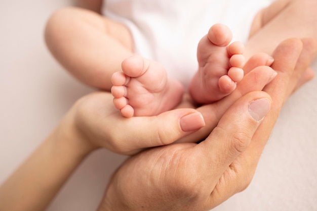 Children39s foot in the hands of mother father parents Feet of a tiny newborn close up Little baby legs Mom and her child Happy family concept Beautiful concept image of motherhood stock photo