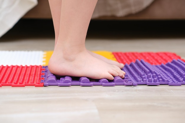 Childrens bare feet walking on an orthopedic massage mat prevention of flat feet in children