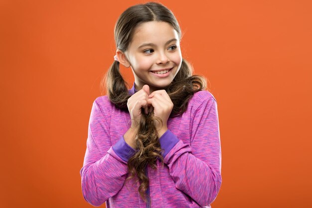 Childrens day Portrait of happy little child Happy little girl with long hair Kid fashion and sportswear Small girl child Hairdresser for kids childhood happiness Family Cheeky little girl