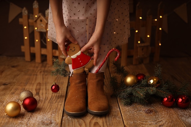 Photo childrens feet in brown shoes new years lollipop and gingerbread in boots