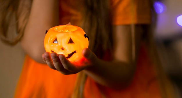 Childrens hand holding a pumpkin for halloween