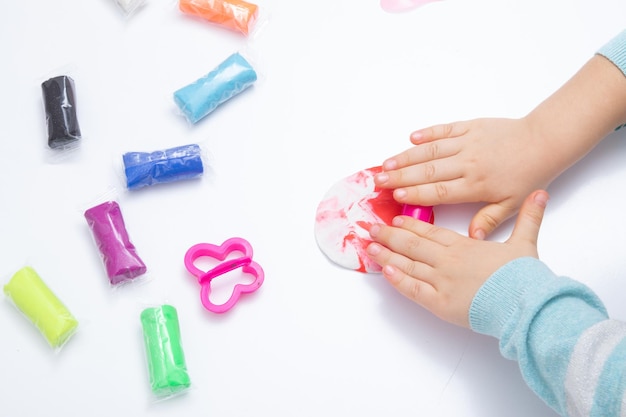 Childrens hands play dough for children's creativity. Board game for the development of fine motor skills