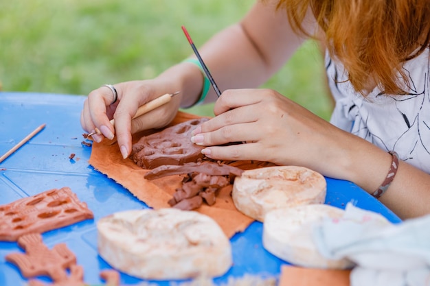 Photo childrens lesson for modeling from natural terracotta clay piece held in hands wet clay material for sculpture or modeling