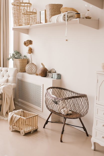 Photo childrens wicker bed for babies in the interior of the childrens room in light beige tones