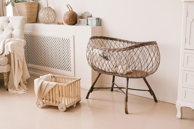 Childrens wicker bed for babies in the interior of the childrens room in light beige tones