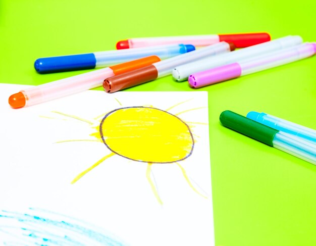 Photo childs drawing of sun and color pens