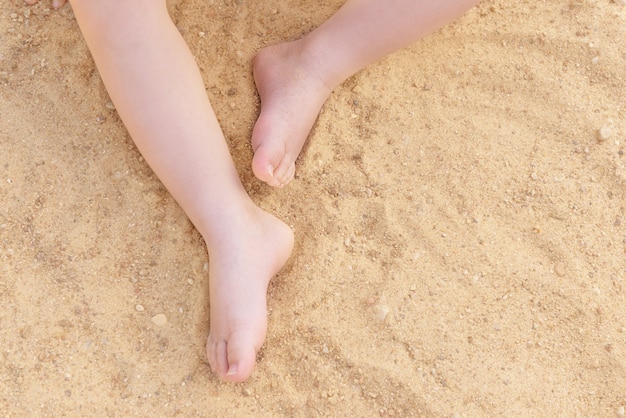 Childs feet on a background of sand