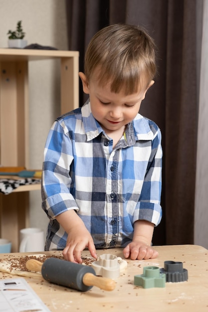 Childs hands making dough cookies using dough molds