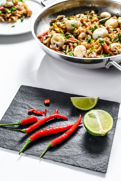 Chili pepper and lime. Selective focus. White background. Top view. Copy space