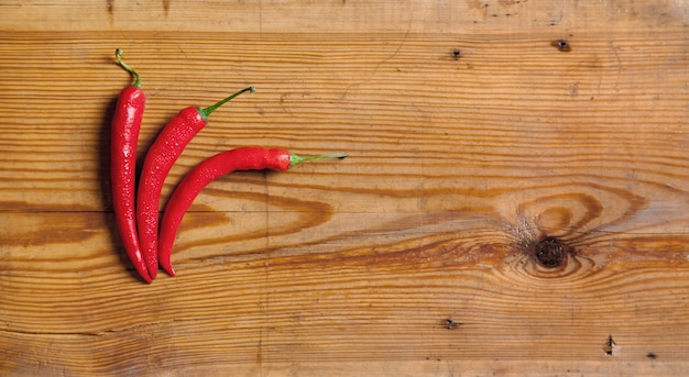 Chili peppers on a decorative board fruit on white