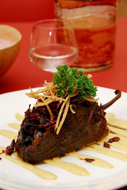 chili stuffed with huitlacoche and chapulines exotic mexican food on red background