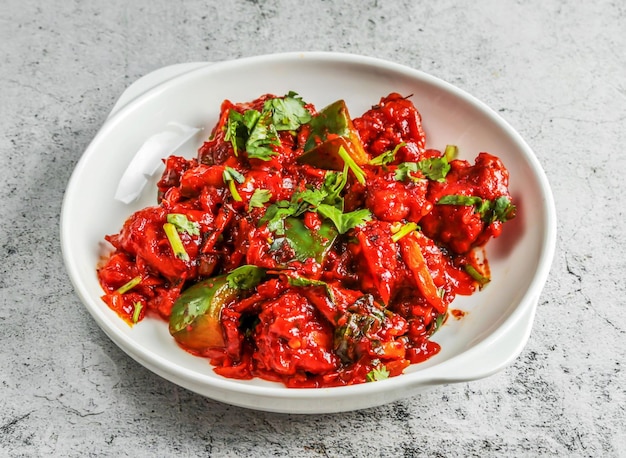 Chilli chicken served in dish isolated on background top view of desi indian food