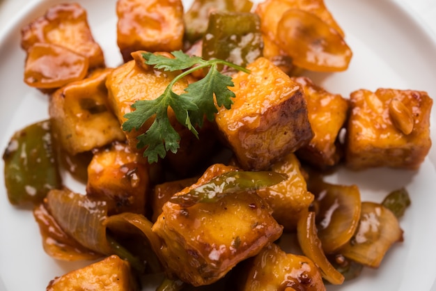 Chilli paneer or Spicy cottage cheese, served in white Dish with capsicum and onion, favourite indian starter menu, selective focus