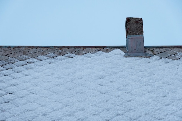 Chimney of fireplace on roof house with snow covered