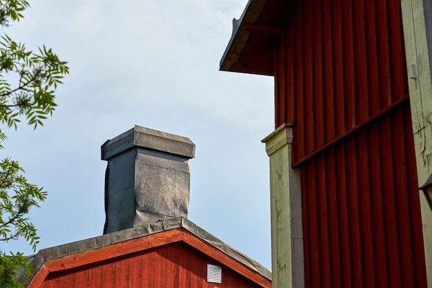 Chimney on an old wooden house with an overcast sky in the background