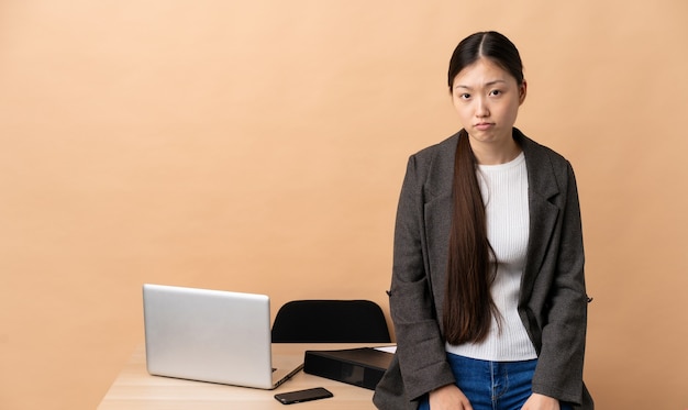 Chinese business woman in her workplace with sad expression