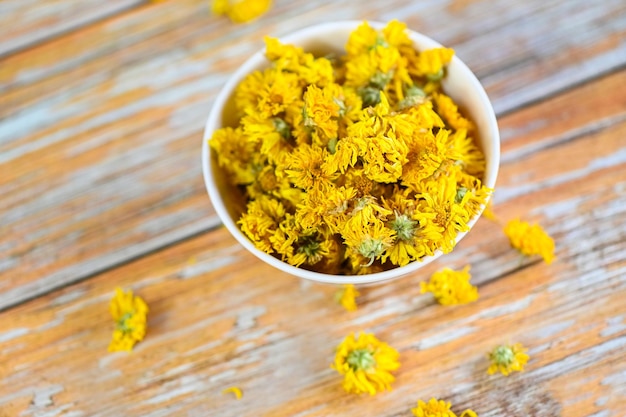 Chinese chrysanthemum flower tea Dried chrysanthemum buds for herbal tea on wooden background dry chrysanthemum flower yellow