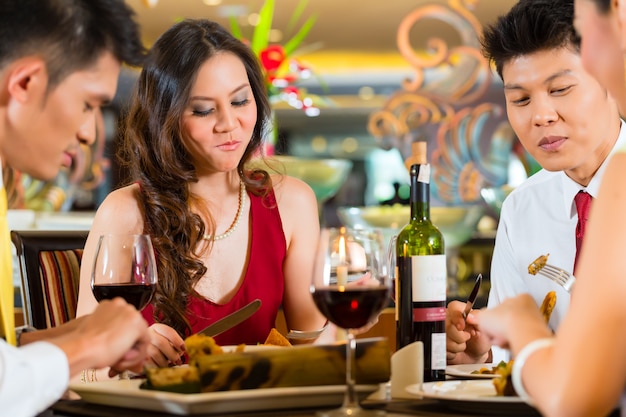 Chinese couples toasting with wine in restaurant