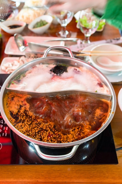 chinese cuisine boiling broth in double wok during cooking hotpot soup