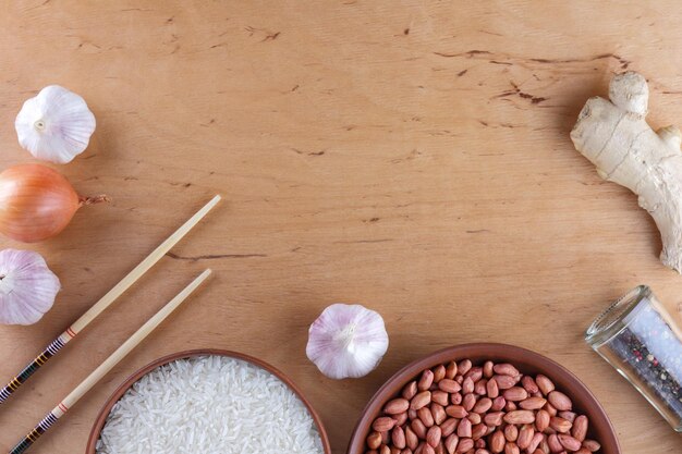 Chinese food ingredients nuts vegetables ginger root Raw rice and spices on wooden background Garlic and onion for cooking Copy space