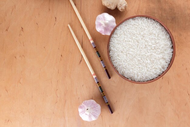 Chinese food ingredients nuts vegetables ginger root Raw rice and spices on wooden background Garlic and onion for cooking Copy space