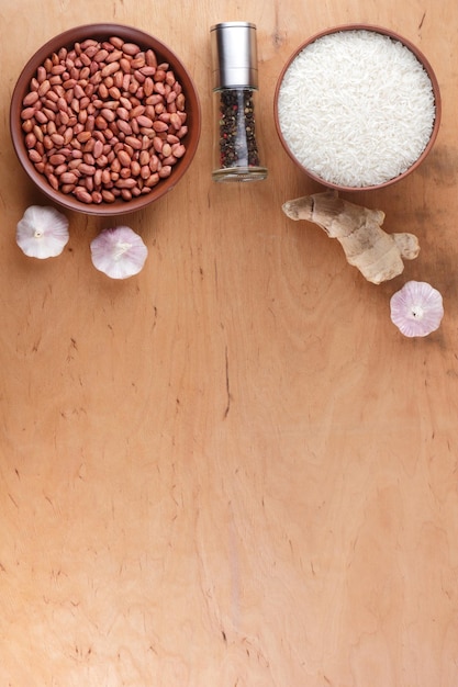 Chinese food ingredients nuts vegetables ginger root Raw rice and spices on wooden background Garlic and onion for cooking Copy space