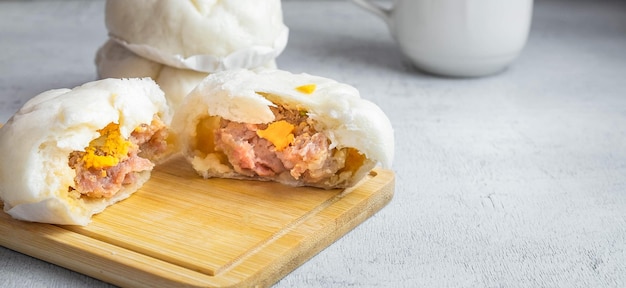 The Chinese food menu of Steamed Buns split in the middle reveals Pork Belly on white table