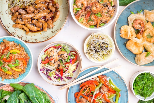 Chinese food on white background. Noodles, fried rice, dumplings, stir fry chicken, dim sum, spring roll