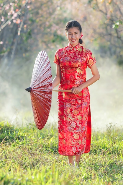 Chinese girl with dress traditional Cheongsam in Garden