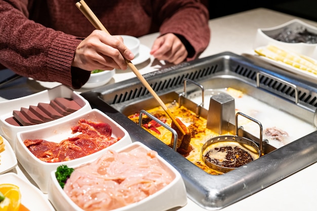 Chinese Hotpot shabu spicy and sour soup with meat and seafood, Suki Chinese style - selective focus