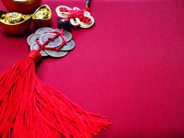 Chinese New Year background. Chinese good luck symbol and ancient golden ingots on red silk fabric with copy space.