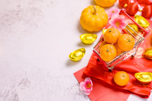 Chinese New Year, Shopping car with orange and China gold ingots,  Traditional Asian style (Foreign text means blessing and lucky)