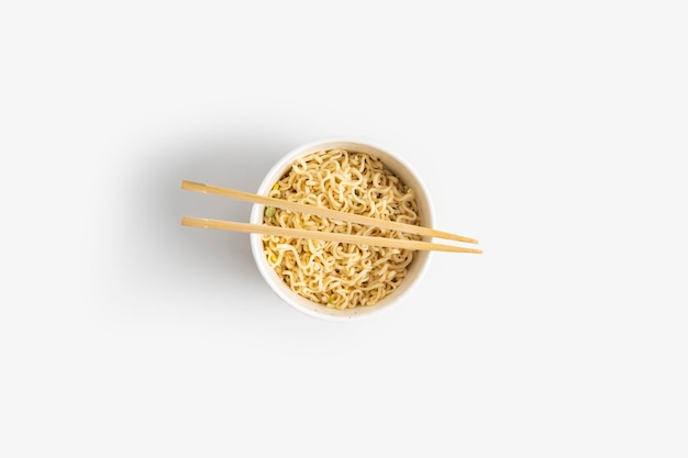 Chinese noodles in a paper mask with wooden chopsticks on a white backgroundTop view flay lay