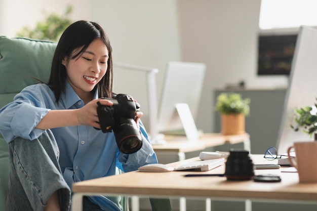 Chinese Photographer Lady Working Holding Camera Sitting In Photo Studio