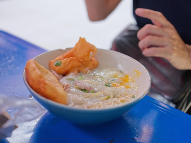 Chinese porridge with egg in a bowel with chinese donughnut Concept breakfast set