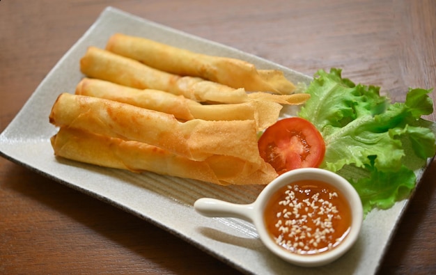 Chinese spring rolls fried with chili sauce and white sesame in a ceramic plate