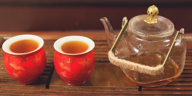 Chinese tea ceremony Ceramic teapot made of clay and bowls on a wooden background