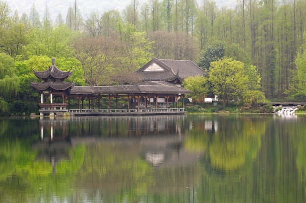 Chinese traditional bridge with pavilion on the coast of West Lake, public park in Hangzhou city, China