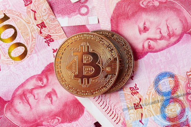 Chinese Yuan money and cryptocurrency Bitcoin close-up. Digital virtual internet currency investment concept