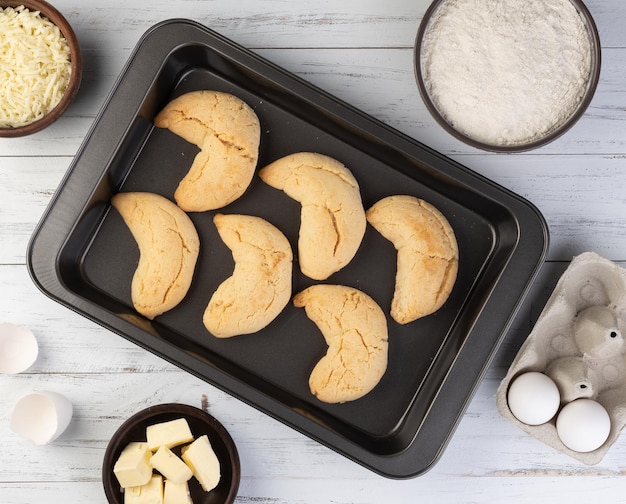 Chipas typical south american cheese bun on a baking tray with ingredients