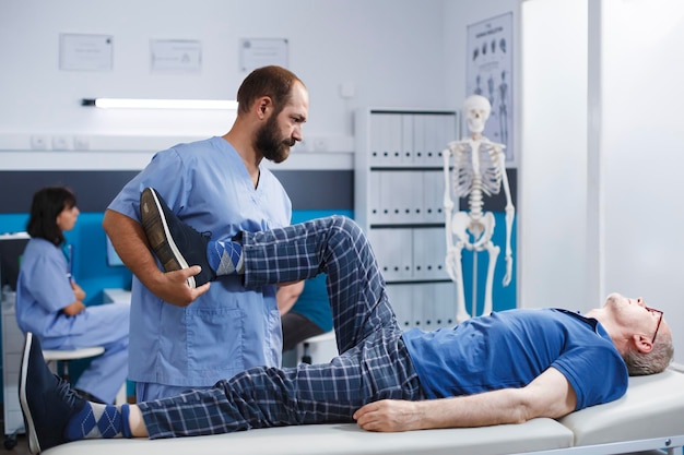 Chiropractor assisting senior patient