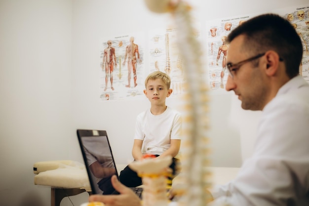 Chiropractor or osteopath does acupressure on back of child with back pain