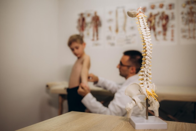 Chiropractor or osteopath does acupressure on back of child with back pain