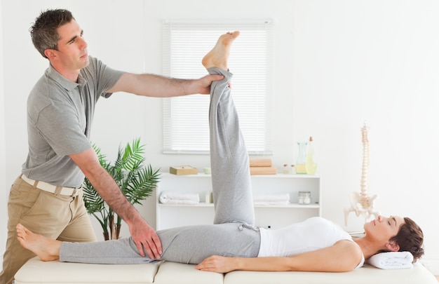 Chiropractor stretching a female's leg